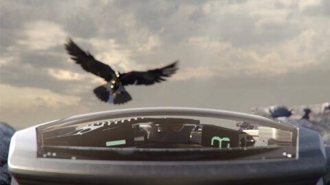 A majestic bird soars above a sleek, futuristic device amidst a rocky landscape, evoking a sense of freedom and the juxtaposition of the natural world with advanced technology.