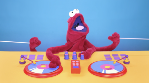 Marionnette rouge DJ avec des platines colorées sur fond bleu et jaune