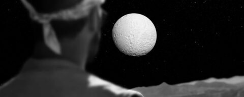 Personne regardant une planète blanche dans l'espace, en noir et blanc.