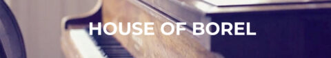 L'image montre un piano en bois avec des touches blanches et noires, et le texte "HOUSE OF BOREL" est superposé en grandes lettres blanches. L'angle de la prise de vue permet de voir une partie du clavier du piano et la texture du bois, donnant une impression de chaleur et de sophistication. L'image est floue en arrière-plan, mettant en avant le texte et la texture du piano.